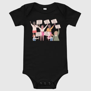 May include: Black baby bodysuit with a graphic of a group of people holding signs that say "Black Lives Matter".