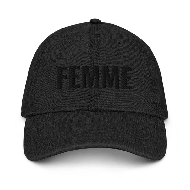 May include: A black denim baseball cap with the word "FEMME" embroidered in black on the front.