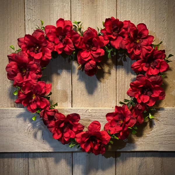 Valentine’s Day wreath.  Heart shaped grapevine base, with red silk delphinium blossoms and boxwood accents.