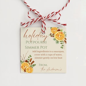 May include: A square gift tag with red and white baker's twine, featuring illustrations of dried orange slices, cinnamon sticks, and greenery. The text reads: holiday POTPOURRI SIMMER POT, instructions to add ingredients to a saucepan with 2 cups of water, and FROM, the Anderson's.