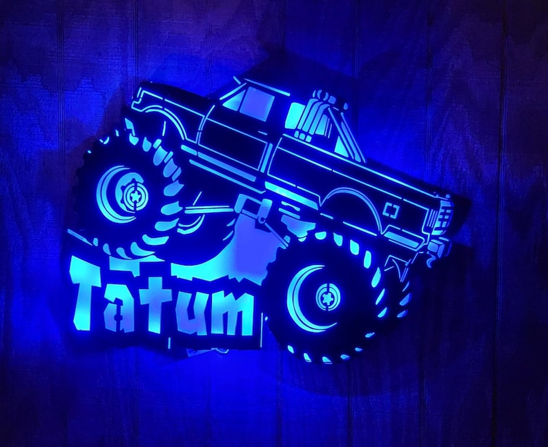 May include: A blue illuminated monster truck silhouette with the name Tatum on the side.