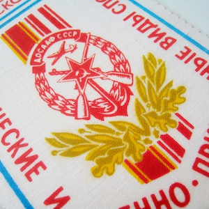 Puede incluir: Un parche de tela blanco con rayas rojas y amarillas, una estrella roja y una corona roja con rifles cruzados y un avión. El texto "ВОСАФ СССР" está dentro de la corona. El texto "ТЕХНИЧЕСКИЕ" está en el lado izquierdo del parche, y el texto "ВПИСЬ" está en el lado derecho del parche. El texto "НО. ПРИКЛАД" está en la parte inferior derecha del parche.