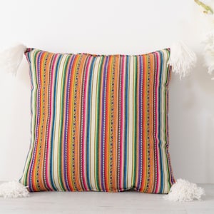 May include: A colorful striped throw pillow with white tassels. The pillow has a cream background with stripes of orange, yellow, green, blue, purple, and pink.