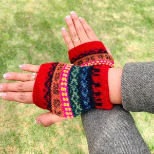 May include: A pair of red knit fingerless gloves with a colorful geometric pattern. The gloves are made of a soft, warm material and are perfect for keeping your hands warm in the winter.