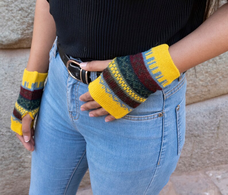 May include: A pair of yellow fingerless gloves with a colorful geometric pattern. The gloves are made of knitted wool and have a warm, cozy feel.