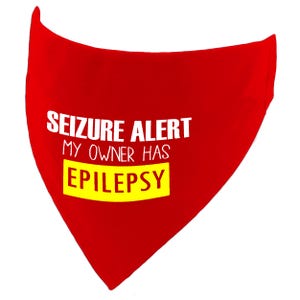 May include: Red bandana with white text that reads "Seizure Alert My Owner Has Epilepsy" in a yellow box.