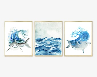 May include: Set of three watercolor prints featuring a white shark, a hammerhead shark, and a blue wave. The prints are framed in gold.