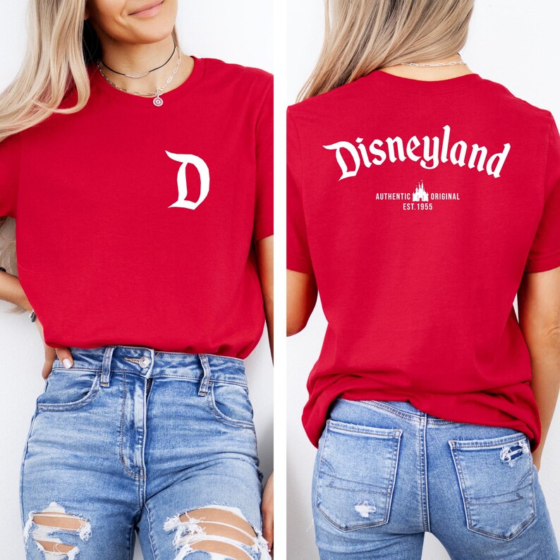 May include: Red t-shirt with a white "D" on the front and "Disneyland" printed on the back. The back also features "AUTHENTIC ORIGINAL EST. 1955". The shirt is a classic crew neck style.