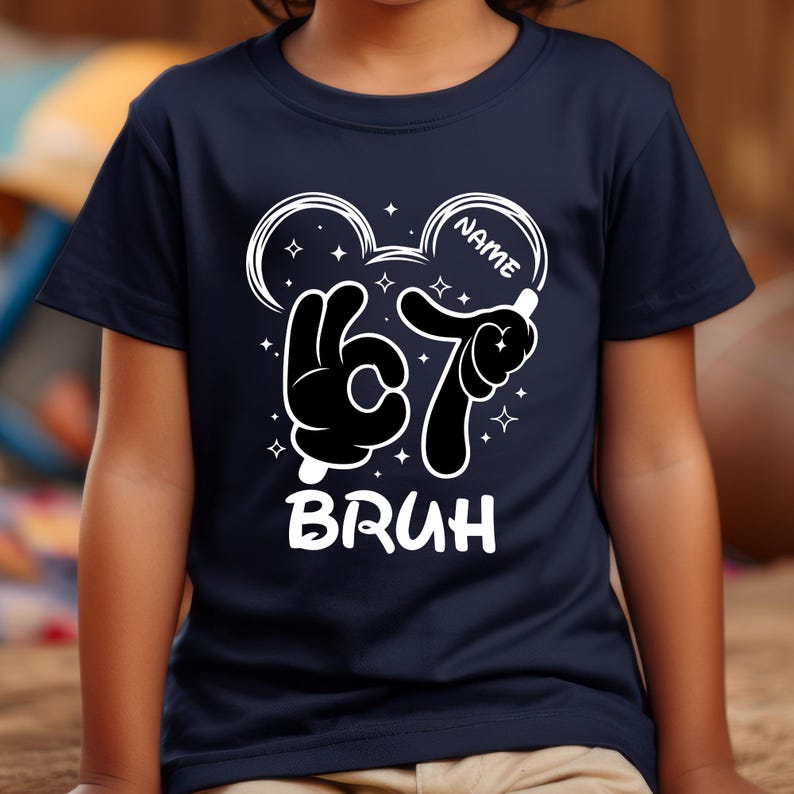 Puede incluir: Camiseta azul marino con un dise&ntilde;o gr&aacute;fico blanco. El dise&ntilde;o presenta manos al estilo de Mickey Mouse formando el n&uacute;mero 67, con la palabra "BRUH" debajo. La palabra "NAME" est&aacute; escrita en un c&iacute;rculo encima del n&uacute;mero.