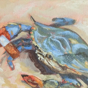 May include: An oil painting of a blue crab with a lit cigarette in its claw. The crab is painted in shades of blue, green, and brown, with a white and red cigarette. The background is a soft, peachy color.