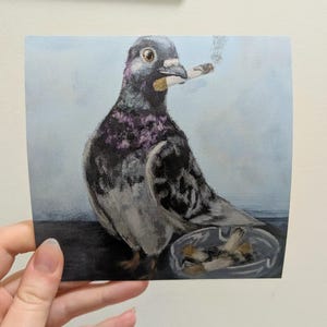 May include: A square painting depicts a pigeon with a cigarette in its beak, smoke rising. The bird has gray, black, and purple feathers. An ashtray with cigarette butts sits below. The background is a light blue.
