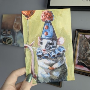 May include: A rectangular painting on canvas featuring a grey and white rat wearing a blue party hat with red pom-poms and a blue ruffled collar. The rat is positioned against a light green background and holds a thin string attached to a red balloon.
