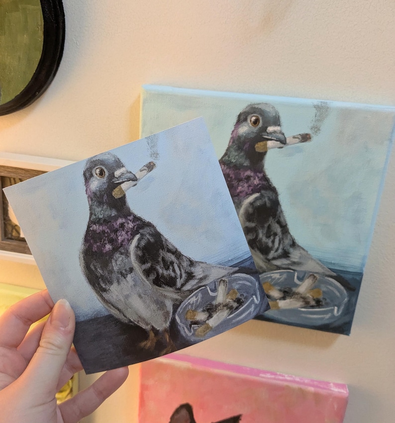 May include: A painting of a pigeon smoking a cigarette, with an ashtray filled with cigarette butts. The bird is depicted in shades of gray, purple, and black against a light blue background. The image is on a square canvas.