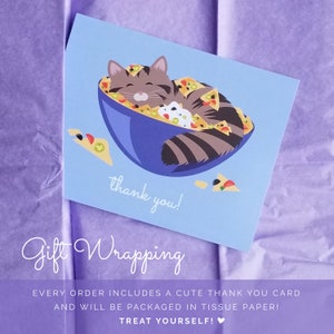 May include: A blue thank you card with a cartoon cat sleeping in a bowl of nachos. The card says "thank you!" and "Gift Wrapping" in a handwritten font. The text below the image says "Every order includes a cute thank you card and will be packaged in tissue paper! Treat yourself!"