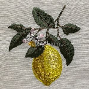 以下が含まれることがあります： 白いリネン地に、緑の葉と白い花が刺繍されたレモンのモチーフ