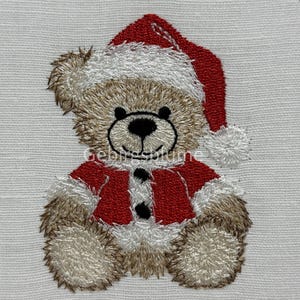 May include: Embroidered teddy bear wearing a Santa hat and jacket. The bear is brown with a black nose and eyes. The Santa hat and jacket are red with white trim. The image is on a white background.