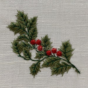 以下が含まれることがあります： 白いリネン生地に赤い実のついた緑のホーリーの枝が刺繍されている