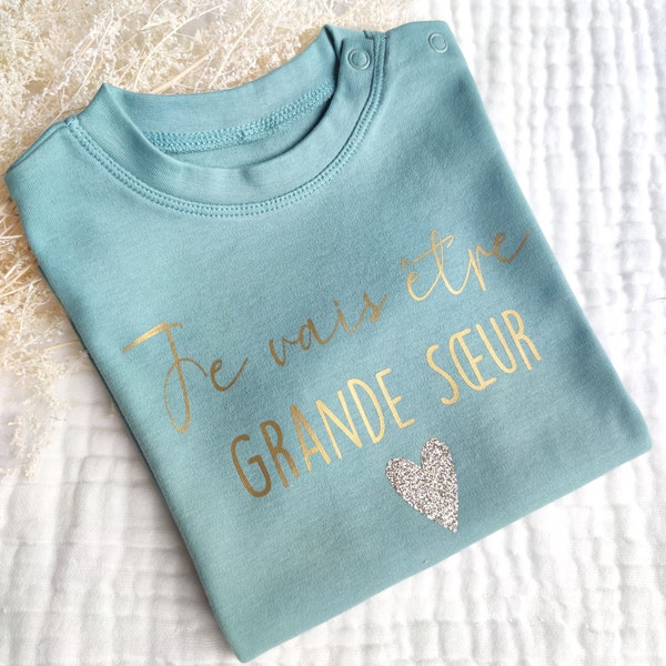 Camiseta de bebé "Voy a ser hermana mayor/hermano mayor" para anunciar un embarazo.