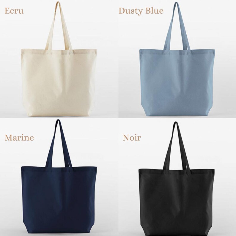 May include: Four tote bags in different colors: ecru, dusty blue, marine, and black. Each bag has a rectangular shape with a long handle. The bags are made of a solid-colored fabric.