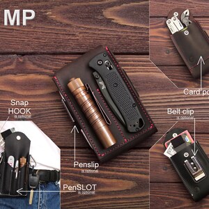 May include: A brown leather wallet with a snap hook, belt clip, and card pocket. The wallet has a pen slot and a penslip. The wallet is shown on a wooden surface.