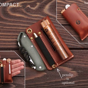 Pu&ograve; includere: Un astuccio compatto in pelle marrone con una penna, un coltello e una torcia. L'astuccio ha una patta che si chiude con un bottone a pressione. Il testo "penslip is optional" &egrave; scritto sotto l'astuccio.