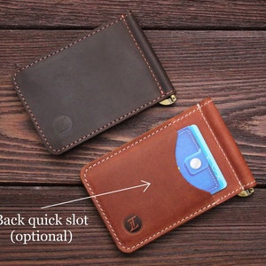 May include: Two leather wallets, one brown and one tan, with a money clip and a slot for a card. The tan wallet has a blue card inside.