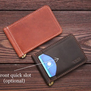 May include: Two leather wallets, one brown and one dark brown, with a money clip and a front quick slot. The wallets are on a wooden surface.