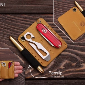 Pu&ograve; includere: Un portafoglio in pelle marrone con due fessure per portare un piccolo coltellino tascabile, un multiutensile e una penna. Il portafoglio &egrave; etichettato "MINI" e ha una fessura per penna opzionale.