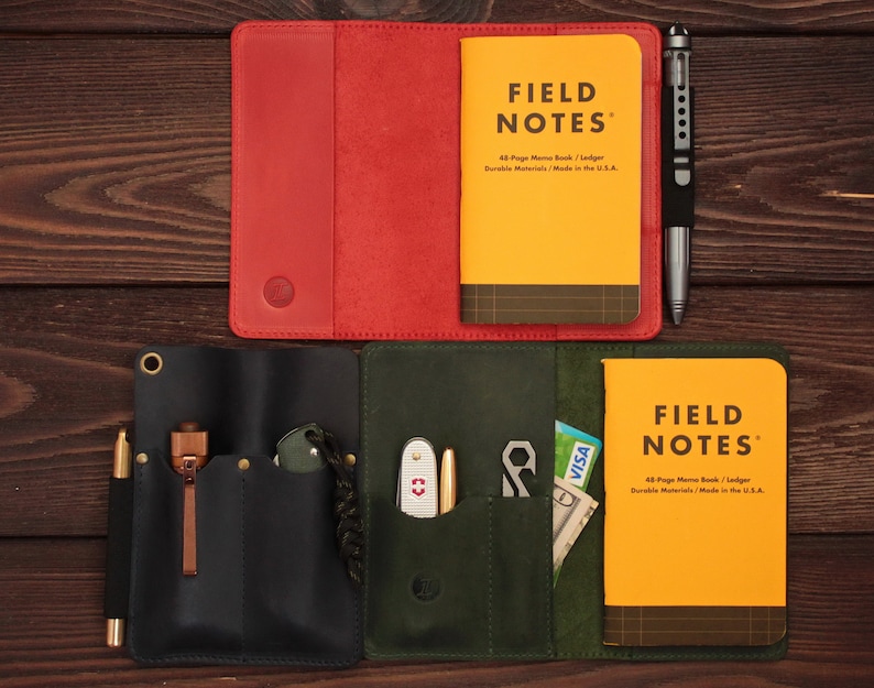 Puede incluir: Dos cubiertas de cuero para cuaderno, una roja y otra verde, con cuadernos Field Notes en su interior. La cubierta verde tiene varios bolsillos y un bol&iacute;grafo, una navaja peque&ntilde;a y una multiherramienta en su interior.