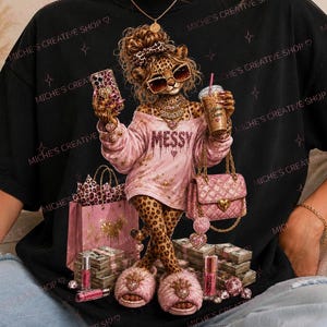 Op de afbeelding: Zwart t-shirt met een afbeelding van een luipaard met een zonnebril, een telefoon en koffie vasthoudend, en een roze outfit met het woord "MESSY". De afbeelding bevat roze accessoires en boodschappentassen.