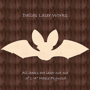 May include: A laser-cut wooden bat silhouette, made from 1/4 inch maple plywood. The bat is flying with its wings spread out. The text "Dallas Laser Works" is at the top of the image. The text "All items are laser cut out of 1/4" Maple Plywood" is at the bottom of the image.