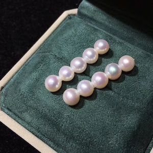 May include: Two rows of five white pearls with a slight pink hue, displayed in a green velvet jewelry box.