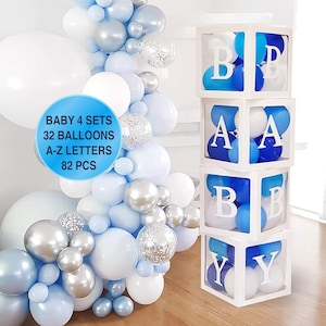 Puede incluir: Un conjunto de cuatro cajas c&uacute;bicas blancas con lados transparentes, apiladas una encima de la otra. Cada caja contiene globos azules y blancos y tiene una letra blanca en la parte delantera. Las letras deletrean "BABY". Las cajas est&aacute;n rodeadas por una guirnalda de globos azules y blancos.