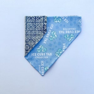 Può includere: Un bandana blu e bianco con un motivo e il testo "ICE CUBE TAX COLLECTOR" ripetuto su di esso.