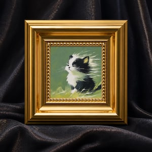 Può includere: Un dipinto quadrato di un gattino bianco e nero con gli occhi chiusi su uno sfondo verde tenue. L'opera è racchiusa in una spessa cornice dorata, ornata e lucida, con un bordo interno a perline che mette in risalto il pelo del gattino.
