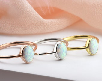 Puede incluir: Tres anillos simples con piedras de ópalo de forma ovalada. Los anillos son de oro, plata y oro rosa.