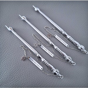 Op de afbeelding: Drie zilveren yad (wijzers) voor het lezen van de Thora, elk met een Davidster-bedel en een zilveren tag met Hebreeuwse tekst.