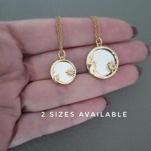 May include: Two gold-toned circular pendant necklaces featuring a crescent moon and a sun motif with a small embedded stone. The pendants have a reflective centre and are suspended from thin gold chains. The text 2 SIZES AVAILABLE is visible.