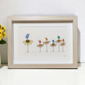 Op de afbeelding: Ingelijst kunstwerk met een kleurrijk kiezelsteenkunstontwerp van vogels die op gele bloemen zitten. De vogels zijn geschilderd in tinten blauw, groen, rood en geel. Het kunstwerk is gesigneerd met "2C".