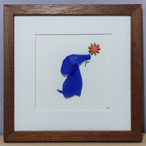 May include: A framed artwork featuring a blue glass dog sniffing an orange flower. The artwork is signed "M.R."