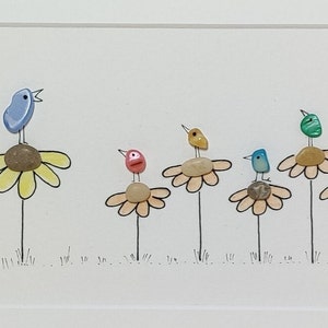 Op de afbeelding: Een kleurrijk beeld van kiezelkunst met zes vogels die op gele bloemen met groene stelen zitten. De vogels zijn blauw, geel, groen, roze en oranje. De achtergrond is wit met de initialen van de kunstenaar "J.K." in de rechterbenedenhoek.