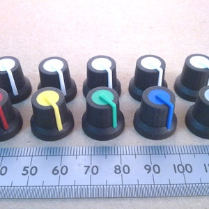 May include: Assortment of ten black knob potentiometers with coloured pointers. The knobs are arranged in two rows of five. The colours of the pointers are red, yellow, green, blue, white, grey, white, white, white, and white.