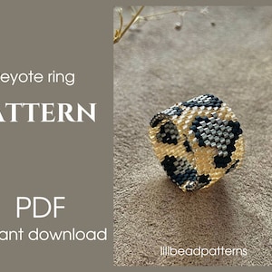 Könnte beinhalten: Ein Perlenring mit Leopardenmuster in Schwarz, Gold und Silber. Der Ring ist in Peyotestich gearbeitet und als herunterladbares PDF-Muster erhältlich.