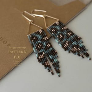 May include: A pair of fringe earrings with a triangle shape and a beaded fringe. The earrings are made with brown, blue, and silver beads. The earrings are 0.78 inches wide and 3.1 inches long. The earrings are made with 5 colors of beads.