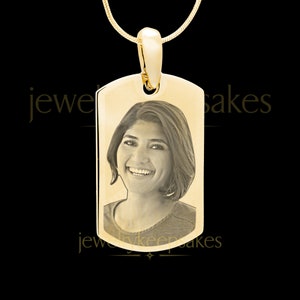 Peut inclure: Collier avec pendentif en or avec une photo d'une femme gravée sur le devant. Le pendentif est en forme de plaque d'identité.