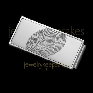 Könnte beinhalten: Rechteckiger Geldclip aus Silber mit einem eingravierten Fingerabdruckdesign auf der Vorderseite. Der Geldclip ist ein Schmuckstück zum Erinnern.