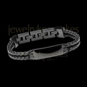 May include: A black bracelet featuring a smooth rectangular center plate and a braided band. The bracelet includes a series of interconnected H-shaped metal links on one side, all finished in a matte black tone, creating a cohesive dark aesthetic.