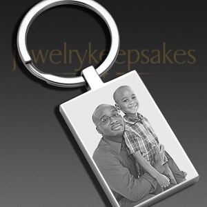 May include: A rectangular silver-toned metal keychain featuring a laser-engraved black and white photograph of an adult and a child. The keychain has a circular split ring at the top and the text JewelryKeepsakes is visible in the background.