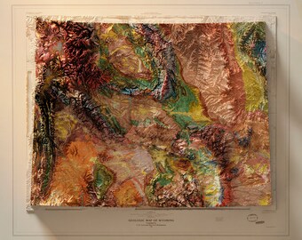 Puede incluir: Un mapa geológico vintage de Wyoming, que muestra el terreno diverso del estado en un estilo de relieve texturizado y colorido. El mapa está titulado "GEOLOGIC MAP OF WYOMING" e incluye un crédito para el U.S. Geological Survey.