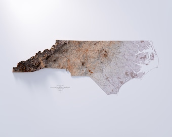 May include: A topographic map of the state of North Carolina, with a textured, raised surface. The map is printed in shades of brown, grey, and white, and shows the state's major roads and rivers.